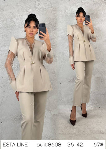 Beige costume by ELVE STYLE SRL featuring intricate lace and elegant design, worn by a model with flowing hair and accessories.