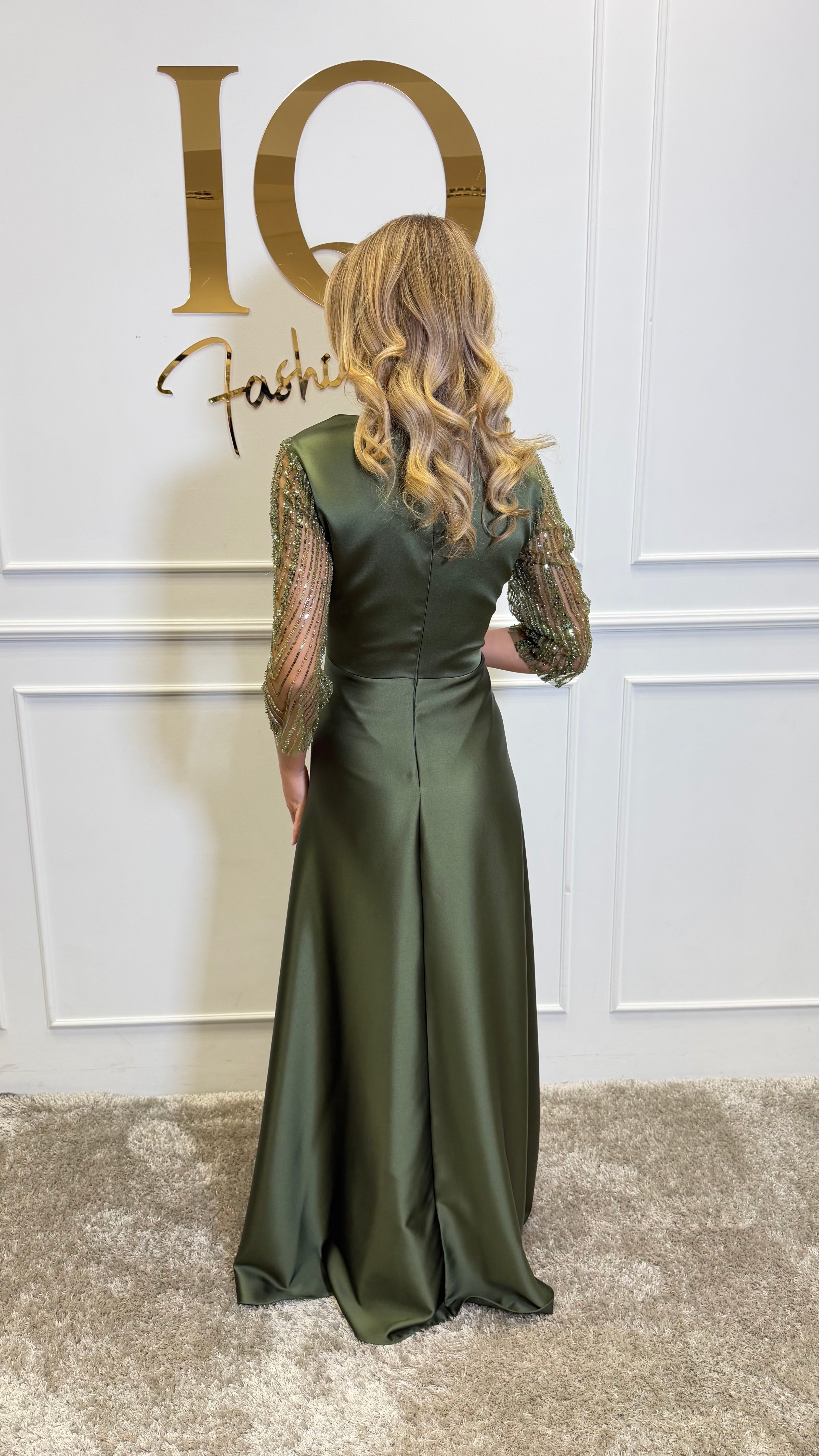Rochie verde oliv Avallyna de la ELVE STYLE SRL, cu croială elegantă și detalii moderne, pe model purtând-o.